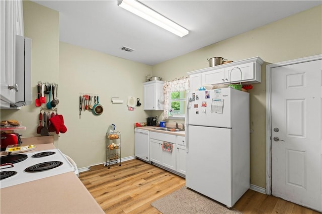 105 E Elm St, Taft, TX 78390 - kitchen featuring white appliances, light wood-style floors, white cabinets, and light countertops