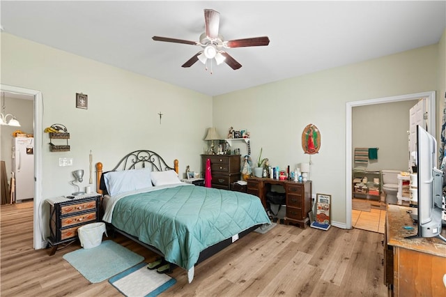 105 E Elm St, Taft, TX 78390 - bedroom with light wood finished floors, a chandelier, ensuite bath, and ceiling fan