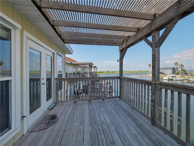 deck with a water view and a pergola