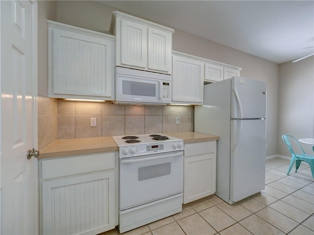 kitchen featuring white appliances, light tile patterned flooring, white cabinetry, and tasteful backsplash