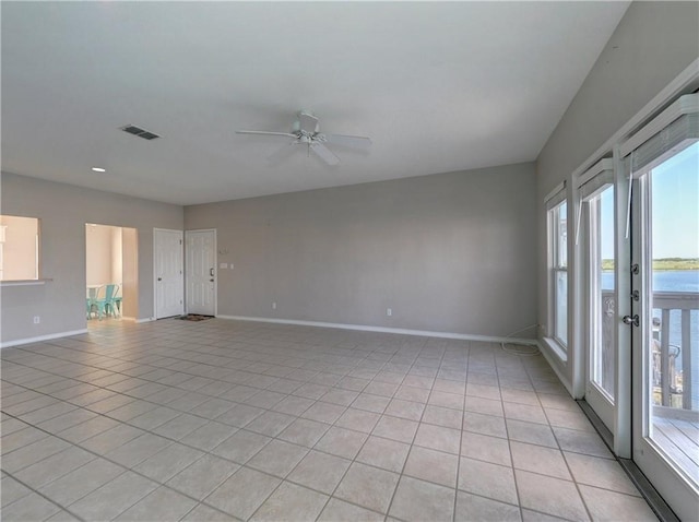 empty room with a healthy amount of sunlight, baseboards, visible vents, and a ceiling fan