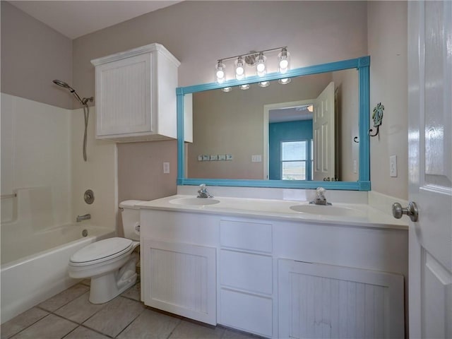 bathroom featuring double vanity, a sink, toilet, and tile patterned floors