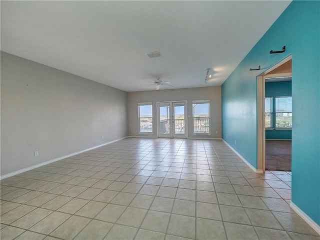 spare room featuring ceiling fan, visible vents, plenty of natural light, and light tile patterned floors