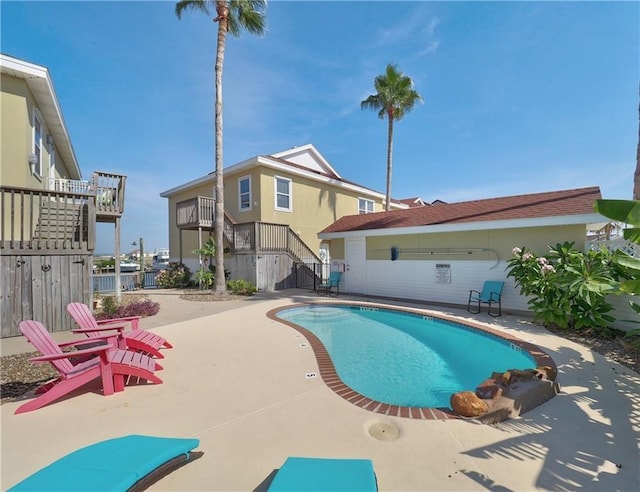 community pool featuring stairs, a patio area, and fence