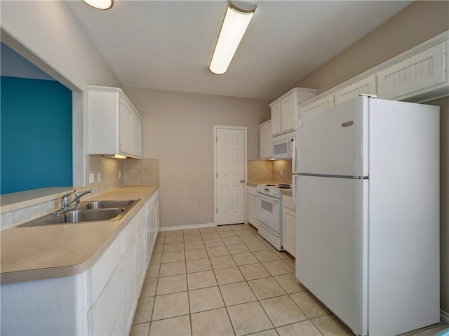 kitchen featuring light tile patterned flooring, white appliances, a sink, white cabinets, and decorative backsplash