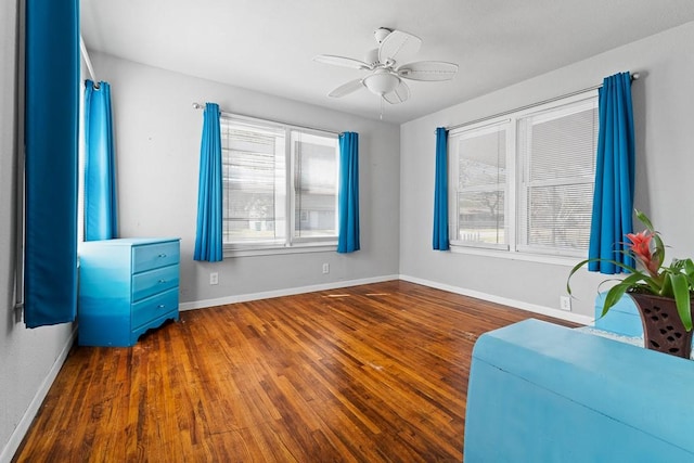 interior space featuring a ceiling fan, baseboards, and wood finished floors