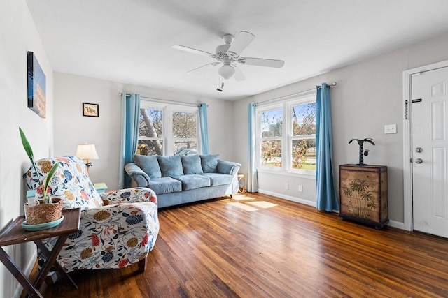 living area featuring ceiling fan, baseboards, and wood finished floors