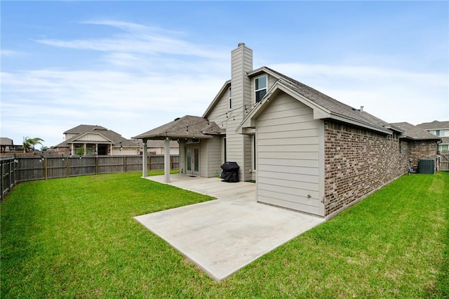 back of house featuring a patio, a fenced backyard, a yard, and brick siding