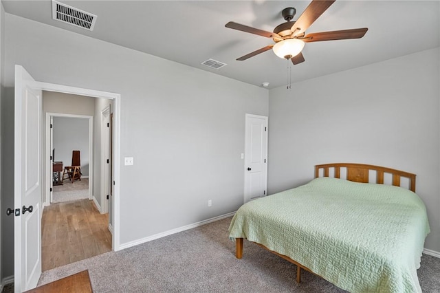 carpeted bedroom with baseboards, a ceiling fan, and visible vents