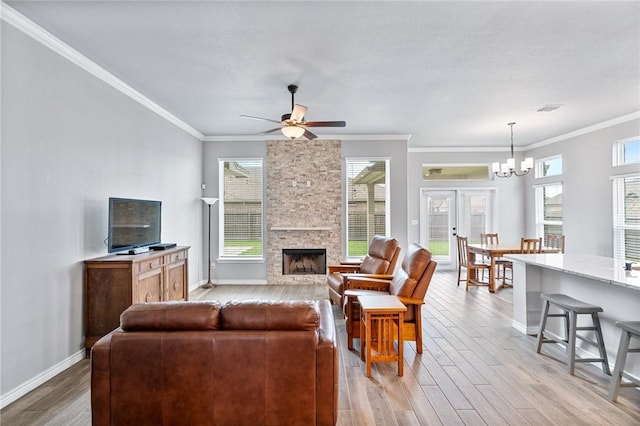 living room with baseboards, ornamental molding, light wood finished floors, and a stone fireplace