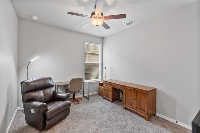 home office with a ceiling fan, baseboards, visible vents, and light colored carpet