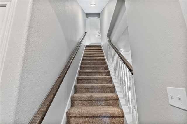 stairs featuring a textured wall