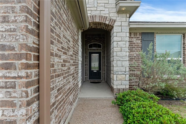 doorway to property featuring brick siding