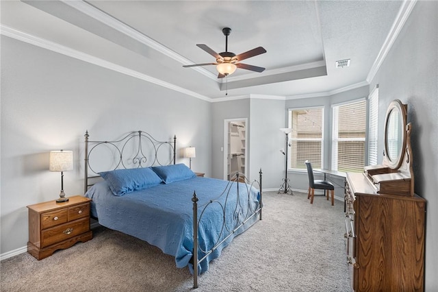 bedroom featuring visible vents, crown molding, carpet floors, baseboards, and a tray ceiling