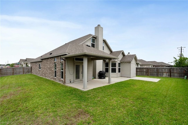 back of house with a chimney, roof with shingles, a patio area, a fenced backyard, and a yard