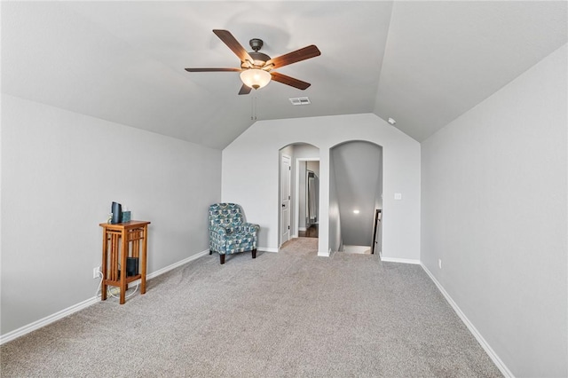 sitting room with visible vents, a ceiling fan, light colored carpet, arched walkways, and an upstairs landing
