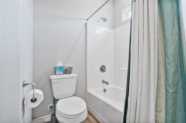 full bath featuring toilet, wood finished floors, and shower / tub combo