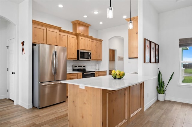 133 Longhorn Dr, Odem, TX 78370 - kitchen featuring stainless steel appliances, arched walkways, light wood-type flooring, tasteful backsplash, and light countertops