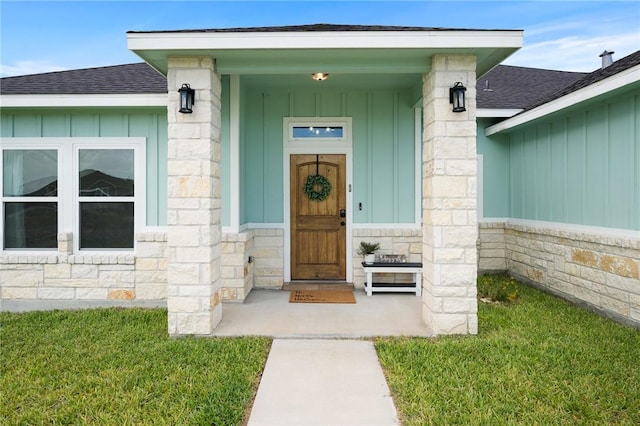 133 Longhorn Dr, Odem, TX 78370 - view of exterior entry featuring board and batten siding, stone siding, and roof with shingles