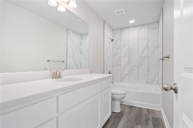 full bath with visible vents, toilet, wood finished floors, shower / bathing tub combination, and vanity