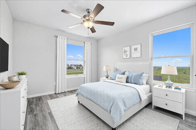 bedroom featuring a ceiling fan, wood finished floors, and baseboards