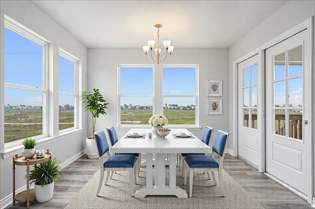 dining room featuring an inviting chandelier, light wood-style flooring, and baseboards