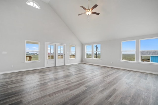 unfurnished living room featuring baseboards, high vaulted ceiling, and wood finished floors