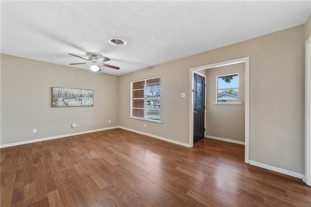 empty room with a textured ceiling, ceiling fan, and hardwood / wood-style floors