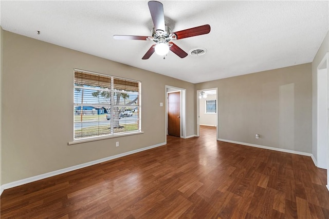 spare room with ceiling fan, a textured ceiling, and dark hardwood / wood-style flooring