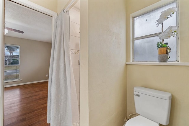 bathroom featuring toilet, wood-type flooring, and a textured ceiling