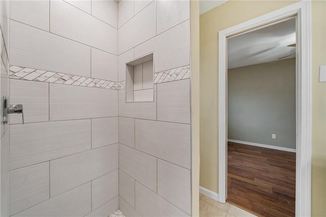 bathroom with tile patterned flooring and tiled shower