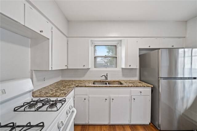 kitchen featuring white cabinetry, sink, white gas stove, and stainless steel fridge