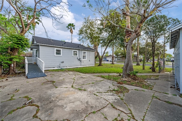 rear view of property featuring a yard and a patio