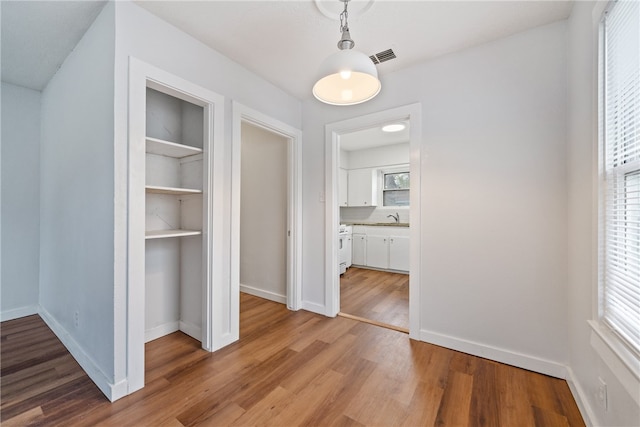 hallway with sink and hardwood / wood-style floors