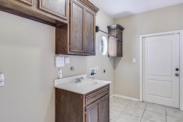 kitchen featuring dark brown cabinetry, sink, and light tile patterned floors