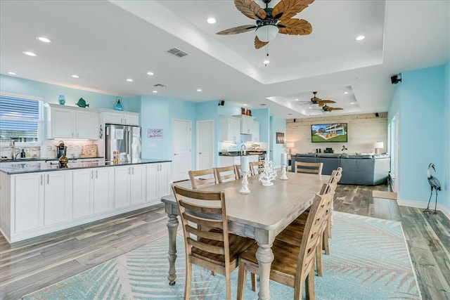 694 Kara Dr, Port Aransas, TX 78373 - dining room with ceiling fan, light wood finished floors, a raised ceiling, recessed lighting, and baseboards