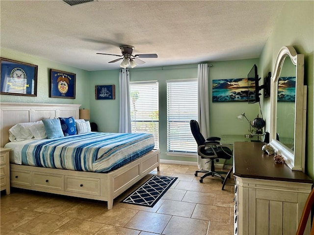 tiled bedroom featuring ceiling fan and a textured ceiling