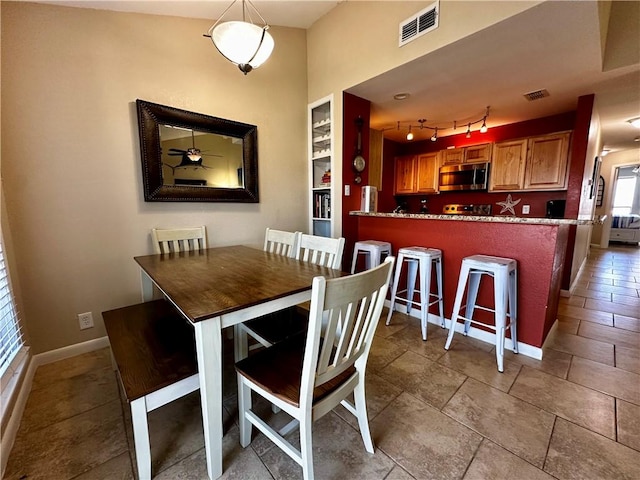 dining space featuring built in shelves and track lighting