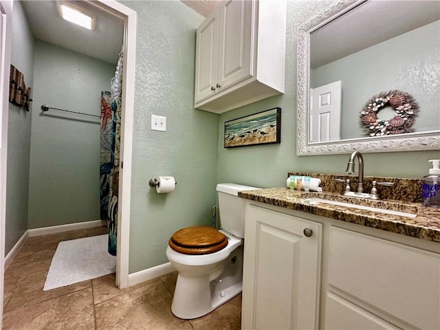 bathroom with tile patterned flooring, vanity, and toilet