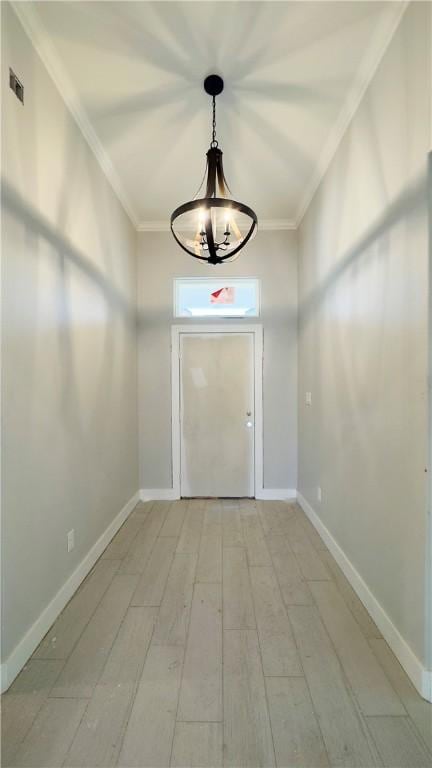 doorway to outside featuring a notable chandelier, baseboards, crown molding, and visible vents