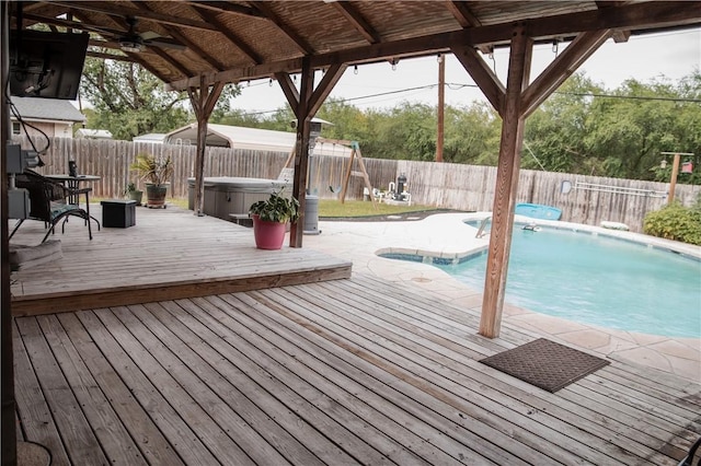 view of pool featuring a fenced backyard, a hot tub, a deck, and ceiling fan