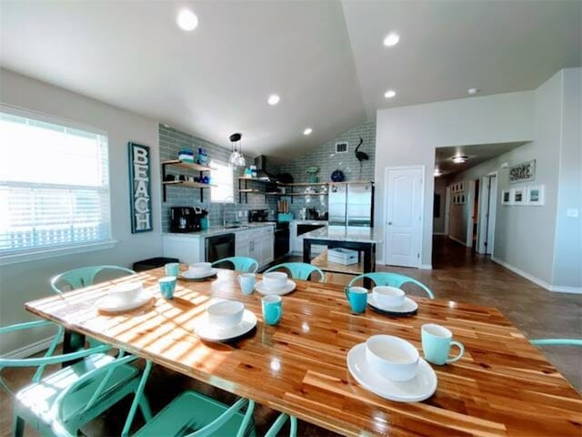 dining space with sink and vaulted ceiling