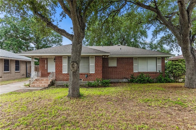 4114 Markins Dr, Corpus Christi, TX 78411 - view of front facade with a porch, brick siding, and a front yard
