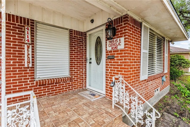 4114 Markins Dr, Corpus Christi, TX 78411 - doorway to property with brick siding, covered porch, and crawl space