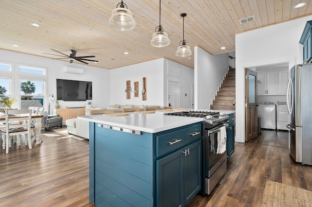 kitchen with pendant lighting, washing machine and dryer, wood ceiling, blue cabinetry, and appliances with stainless steel finishes