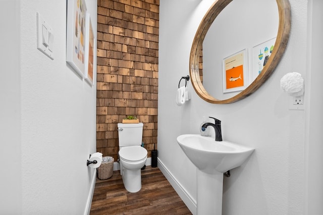 bathroom with toilet, wood-type flooring, and sink