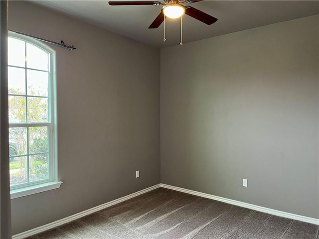 2212 Tallow Dr, Portland, TX 78374 - spare room featuring baseboards, a ceiling fan, a healthy amount of sunlight, and dark carpet