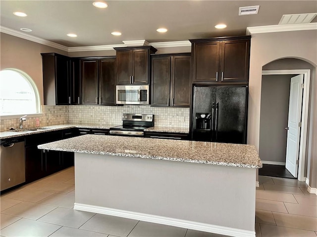 2212 Tallow Dr, Portland, TX 78374 - kitchen with visible vents, appliances with stainless steel finishes, light tile patterned flooring, arched walkways, and a sink