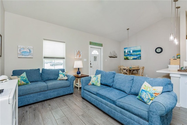 living area with vaulted ceiling and light wood-style floors