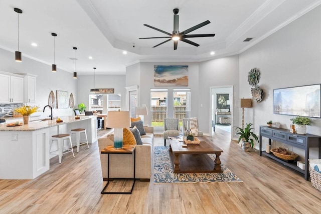 5810 Bella Di Giorno Dr, Corpus Christi, TX 78414 - living area featuring a raised ceiling, ceiling fan, recessed lighting, crown molding, and light wood finished floors